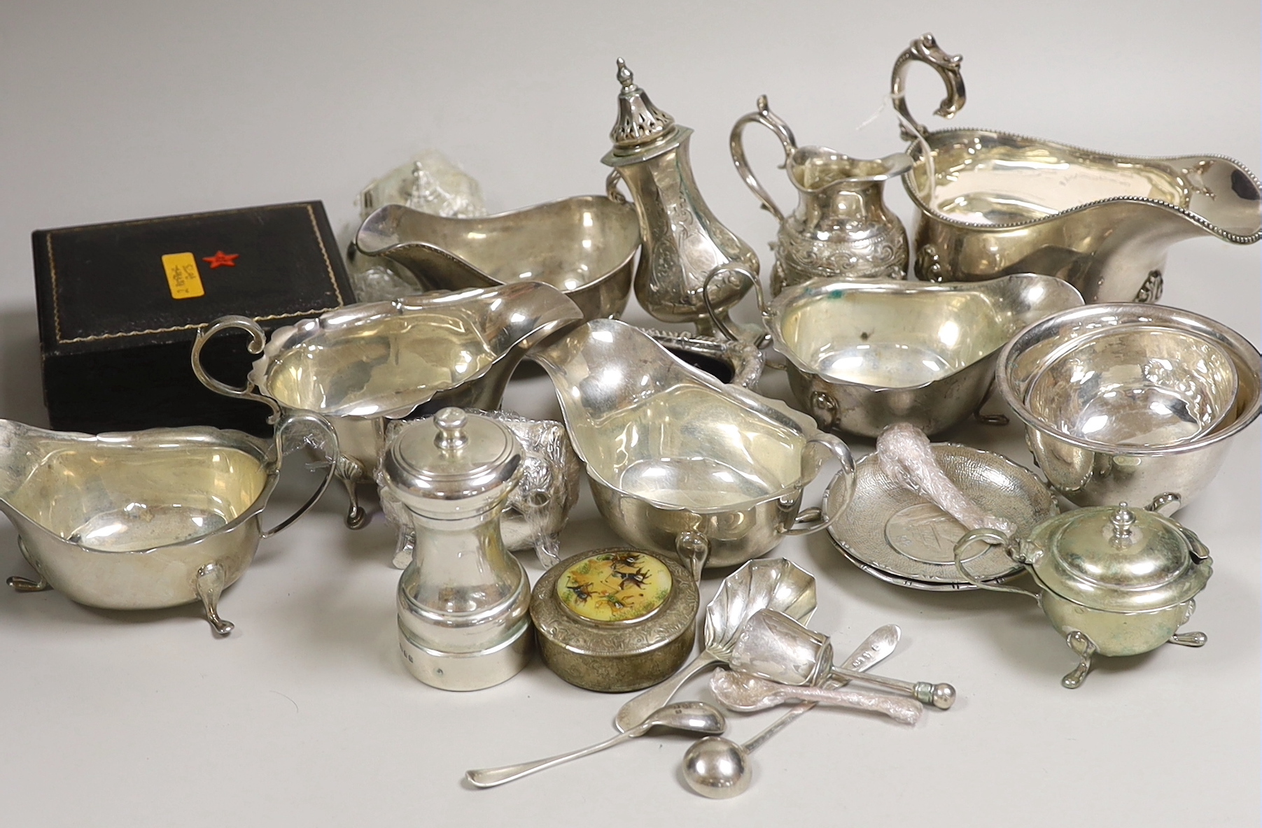 A mixed collection of small silver and plated items to include five various sauceboats, a cased pair of pepper pots, a chased Victorian sugar sifter, two caddy spoons, a silver mounted peppermill, two Chinese coin-set tr